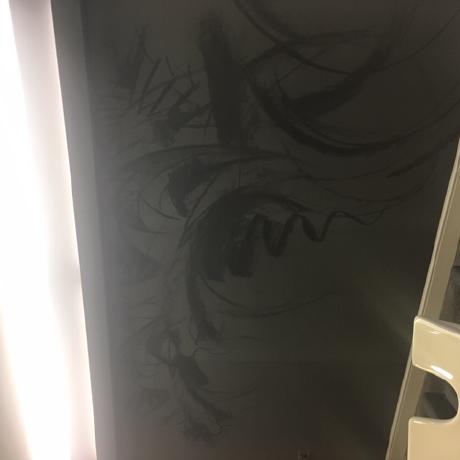 A feature wall in a professional salon setting featuring a custom charcoal-style artistic mural on a dark grey background. The space includes integrated ceiling lighting and white salon wash units, showcasing specialist decorative painting and wall-finishing services in Islington, Canary Wharf, and Covent Garden.